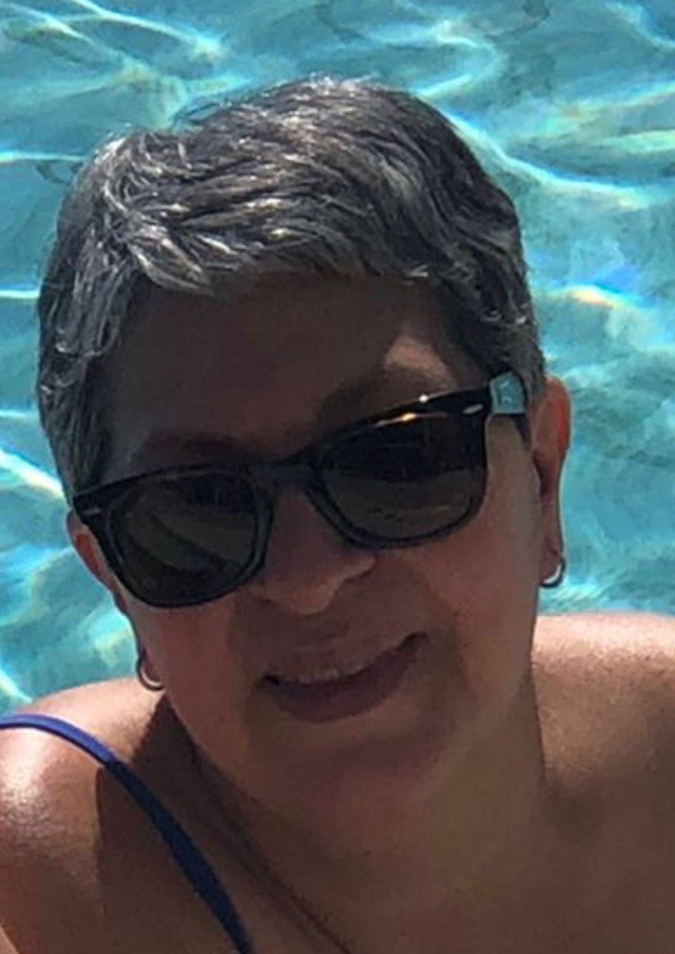Retrato en primer plano de una mujer con gafas de sol en una piscina