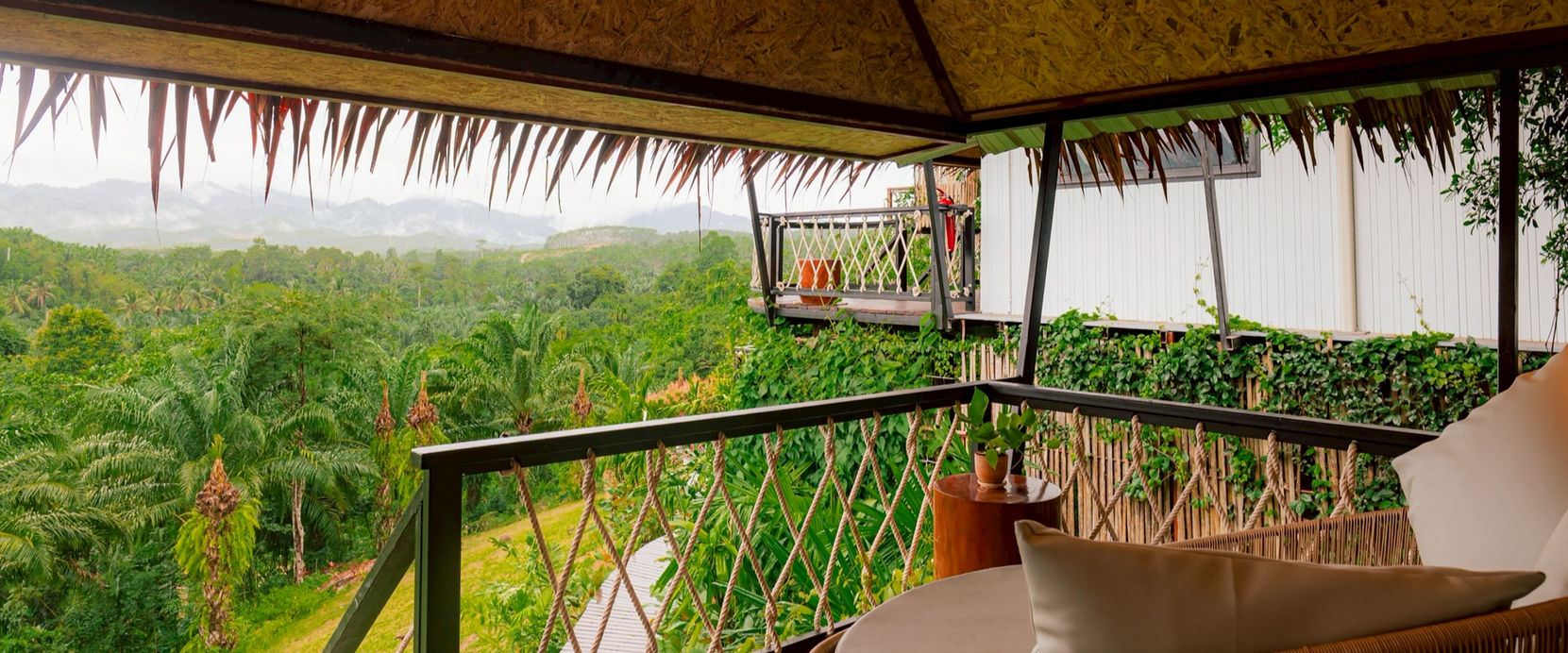 Covered balcony with seating overlooking tropical gardens at Khao Sok Boutique Camps
