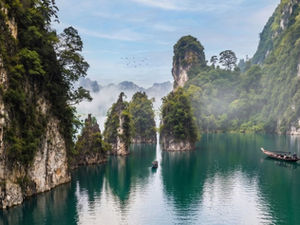 Explore the emerald waters and dramatic limestone cliffs of Cheow Lan Lake by traditional long-tail boat