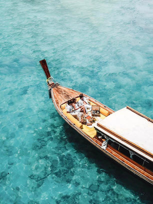 Traditional longtail boat floating on clear turquoise water at Cheow Lan Lake in Khao Sok