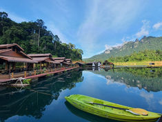 Klong Ka Raft House with green kayak and limestone mountains on Cheow Lan Lake