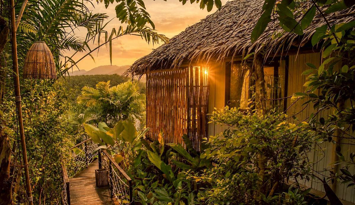 Private Sunset View bungalow glowing in the evening surrounded by tropical plants