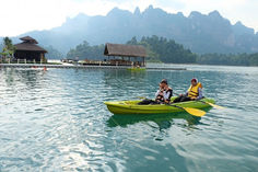 Guests kayaking on Cheow Lan Lake surrounded by limestone mountains in Khao Sok