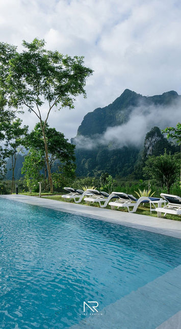 Infinity pool overlooking forested Khao Sok mountains wrapped in low morning clouds