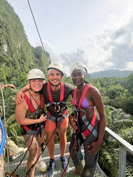 Three friends in helmets and harnesses posing together during a Khao Sok zipline tour