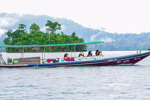 Traditional longtail boat carrying travelers across Cheow Lan Lake in Khao Sok