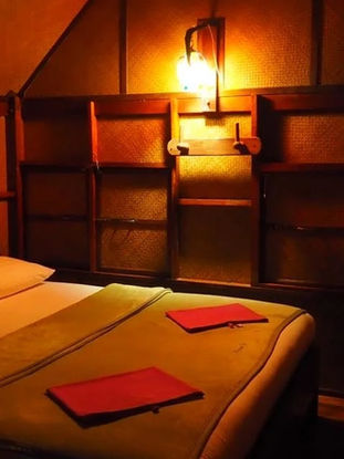 Cozy wooden bedroom with double bed inside Praiwan Raft House on Cheow Lan Lake
