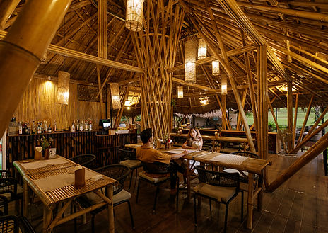 Open-air bamboo restaurant with warm lighting wooden tables and natural handcrafted interior design in Khao Sok