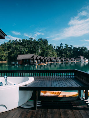 Private floating villa terrace with outdoor bathtub overlooking Cheow Lan Lake at 500 Rai Floating Resort