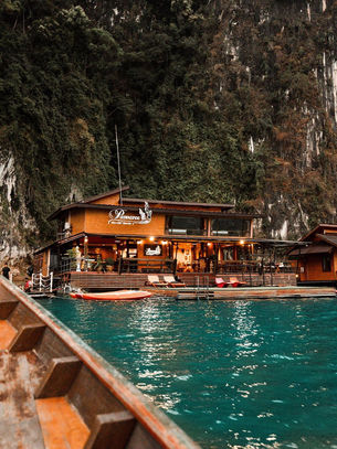 Floating resort beside limestone cliffs and turquoise water on Cheow Lan Lake in Khao Sok