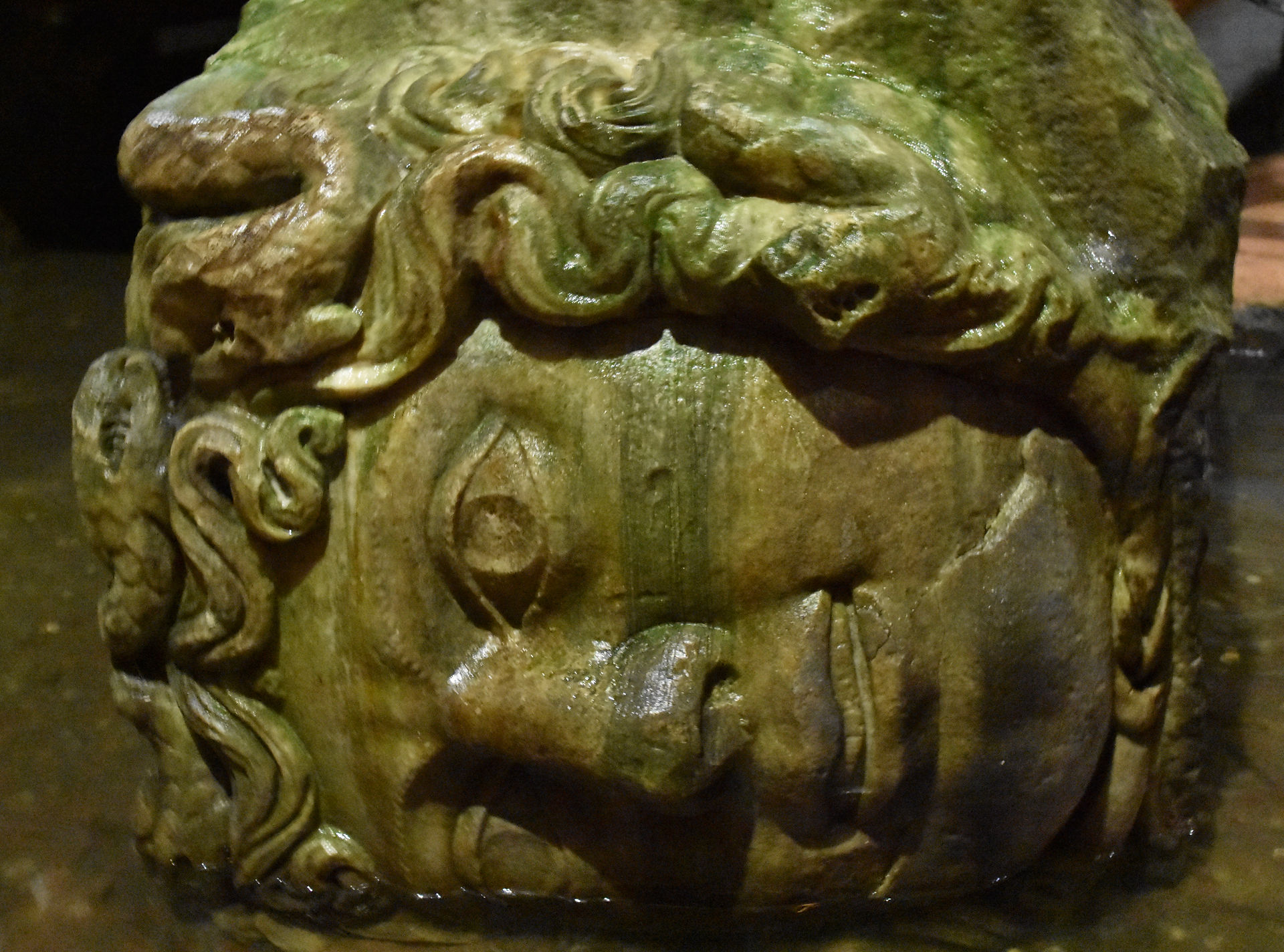 Sideways head of Medusa column pedestal