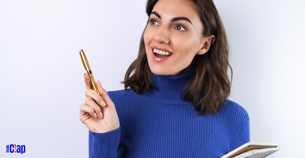 Une dame qui sourit et regarde en l'air avec un stylo dans une main et un cahier dans l'autre