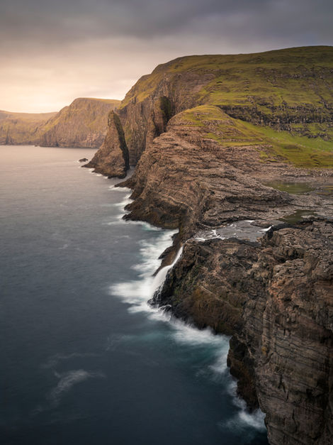 Küste, Wasserfall und Klippen bei Trælanípa auf der Insel Vagar, am See Leitisvatn. Letzte Sonnenstrahlen bei Sonnenuntergang.

Vagar, Färöer Inseln