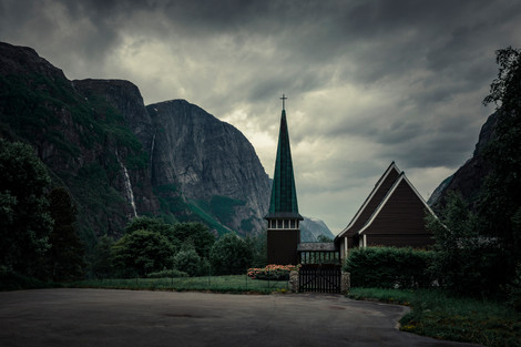 Kirche in Lysebotn, umgeben von Bergen mit Wasserfällen in Norwegen, dunkle Wolken am Himmel.

Lysebotn, Rogaland, Norwegen, Skandinavien
