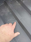 Hand pointing at a damaged roof section, close up inspection for Pro Inspect Home