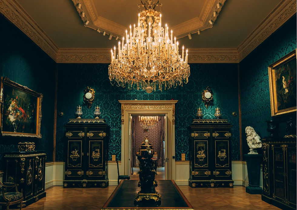 Grand room with teal damask walls, ornate crystal chandelier, black lacquered cabinets, and gold decorative accents throughout.