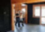 Couple reviewing architectural plans in partially remodeled home with exposed wood and modern finishes.