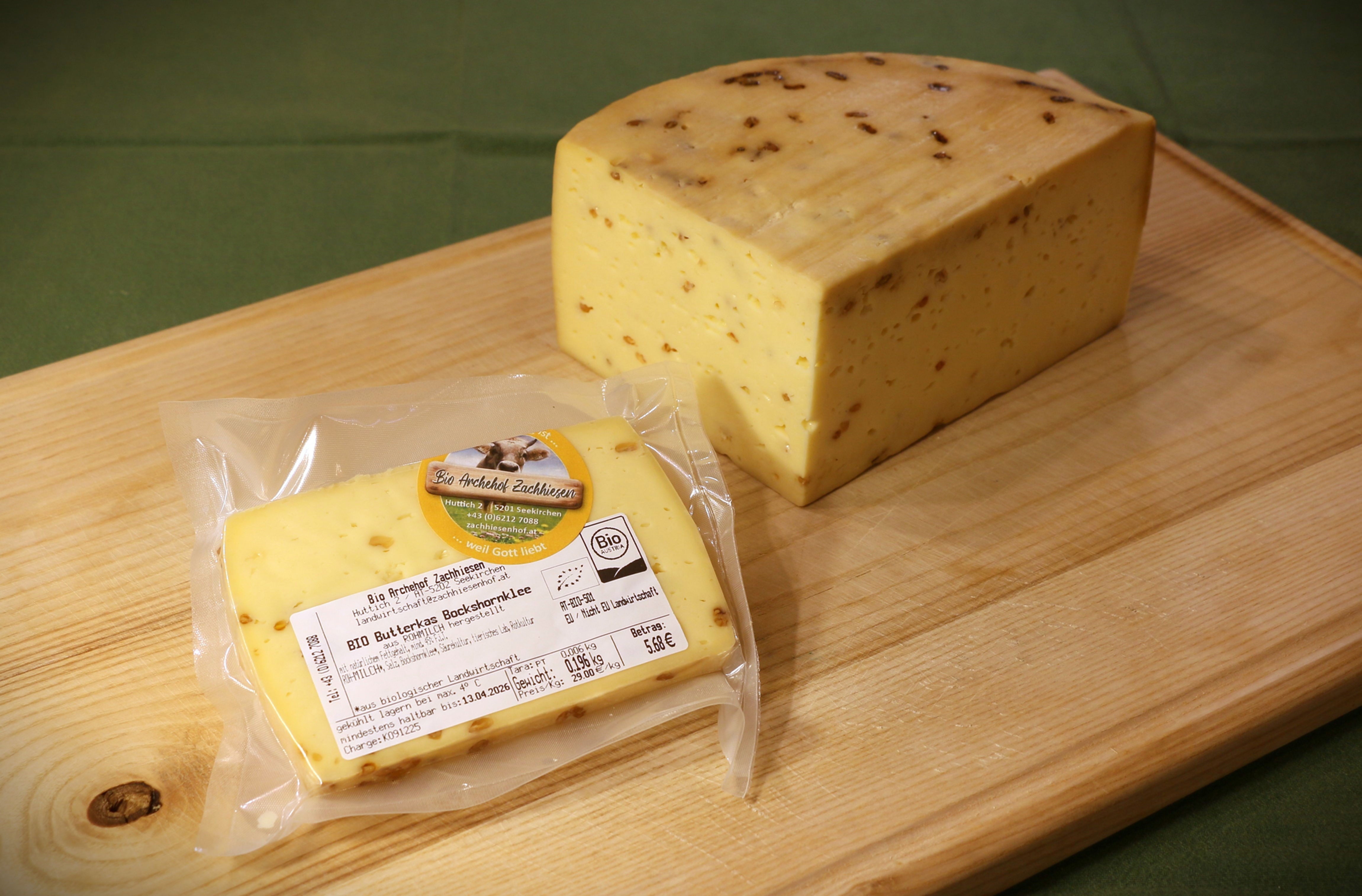 Hausgemachter BIO Grillkäse, ein Stück verpackt, auf Holzbrett