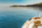 wide-shot-white-canoe-body-water-near-green-island-clear-blue-sky copia.jpeg