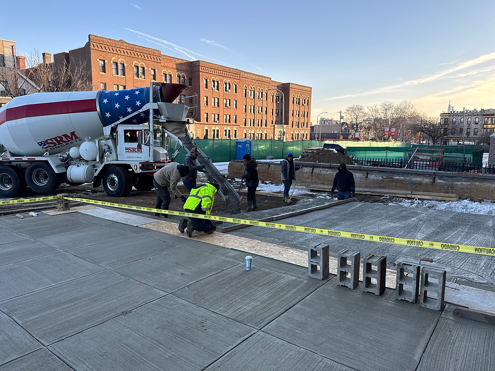 Workers pouring and leveling concrete pavement