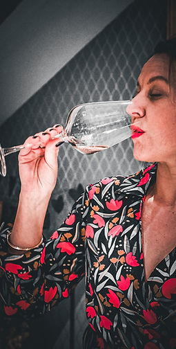Femme goûtant un vin lors d'une dégustation en Normandie.
