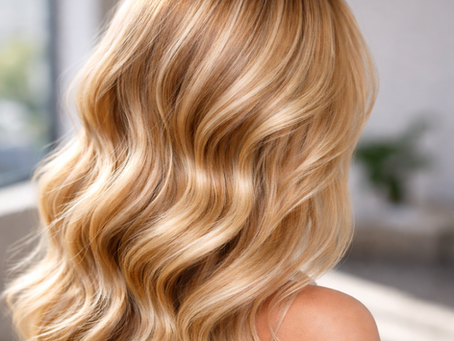 Soft waves of freshly colored blonde hair in natural sunlight showing dimension and blended highlights