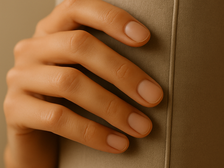 Natural nails on a gently resting hand, photographed in soft daylight to highlight balance, simplicity, and nail health