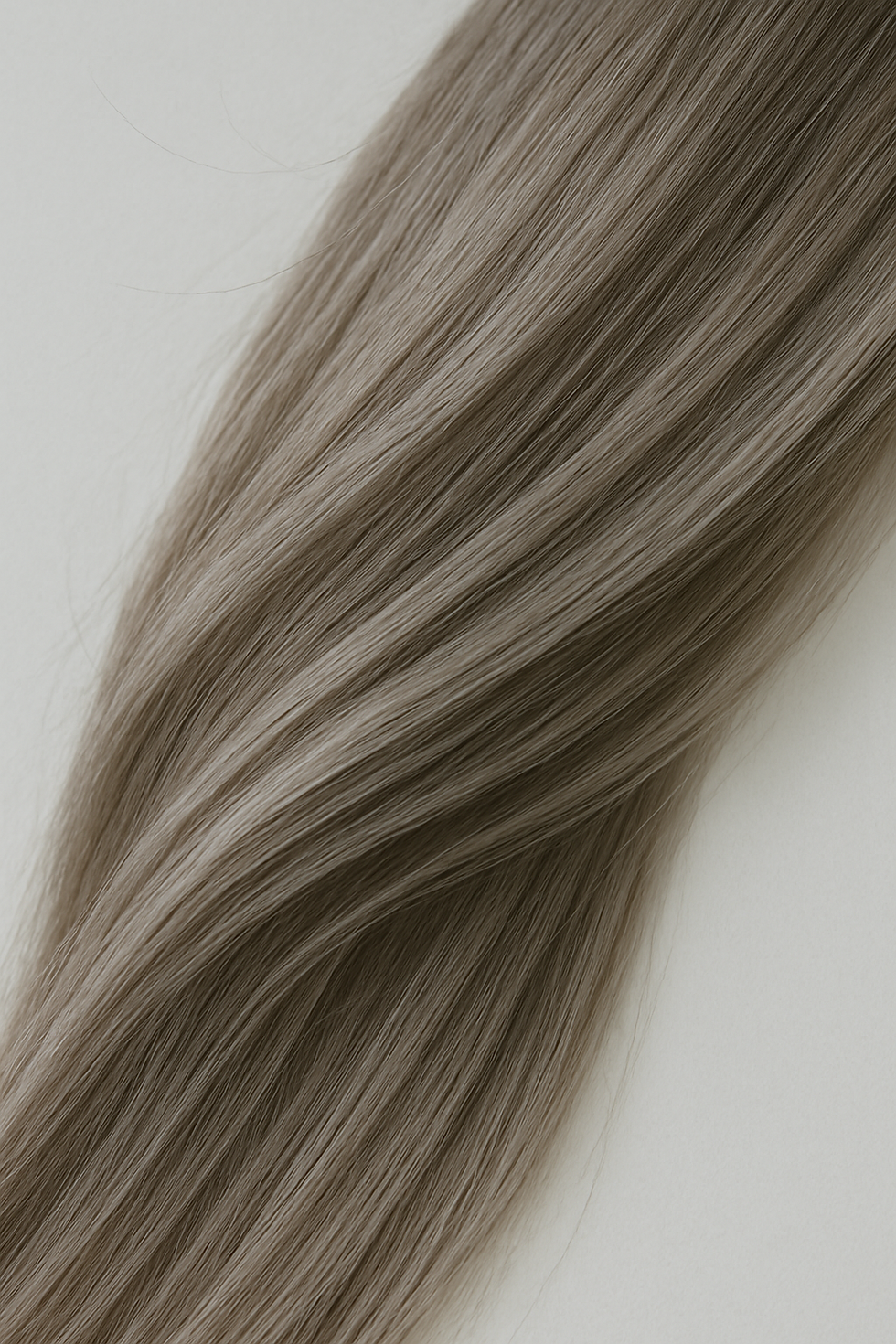 Macro detail of healthy hair strands in soft neutral light, highlighting texture and natural movement