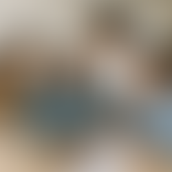 Four people smile while discussing charts at a table with a laptop. Bright, casual setting with a white brick wall background.