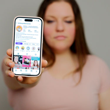 A woman in a pink shirt holds a phone showing an Instagram profile with Instagram features explained for Instagram content types.