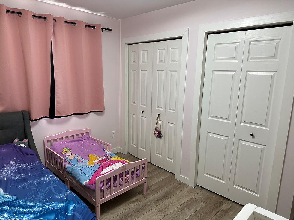 Pink kids' bedroom with princess bedding, two twin beds, pink curtains, and white closet doors on wood flooring showing a Second closet added to kids bedroom for extra storage