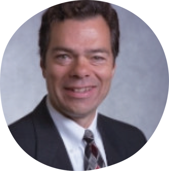 Man with dark brown hair, black suit jacket and tie smiling.