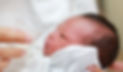 newborn baby drinking breast milk from a cup