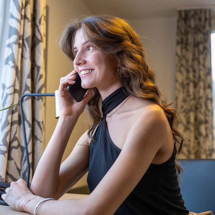Junge, hübsche Dame telefonierende im Hotelzimmer, Hotel Restaurant Guggital, Zug