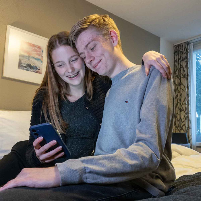 Junges Paar im Hotelzimmer auf dem Bett sitzend, Hotel Restaurant Guggital, Zug