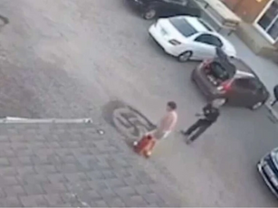 Man drawing Nazi Kakenkreuz on pavement