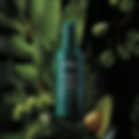 A bottle of Botanical Repair Overnight Serum with leaves and botanicals in the background