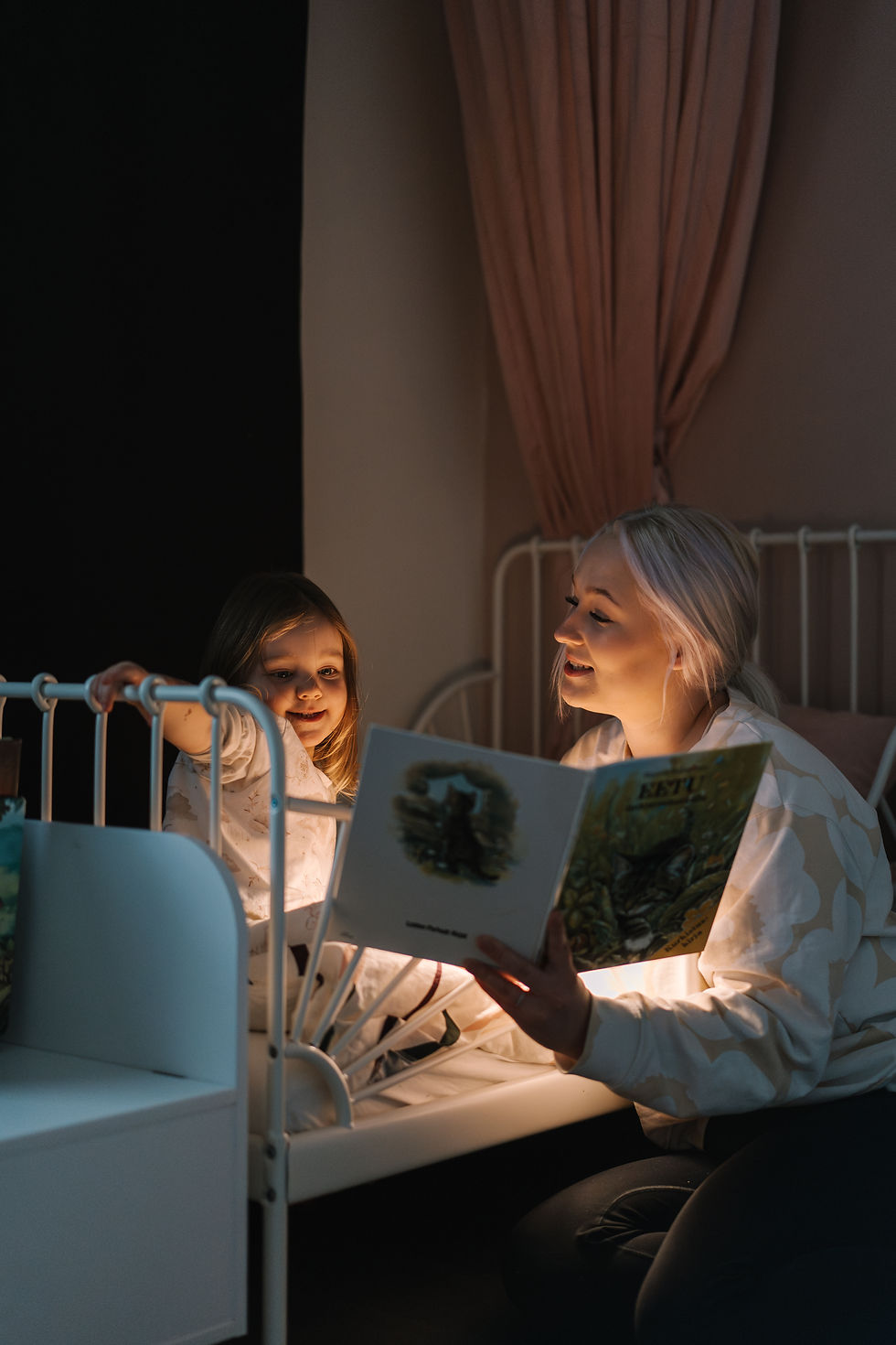 Hoivaaja lukee iltasatua lapselle