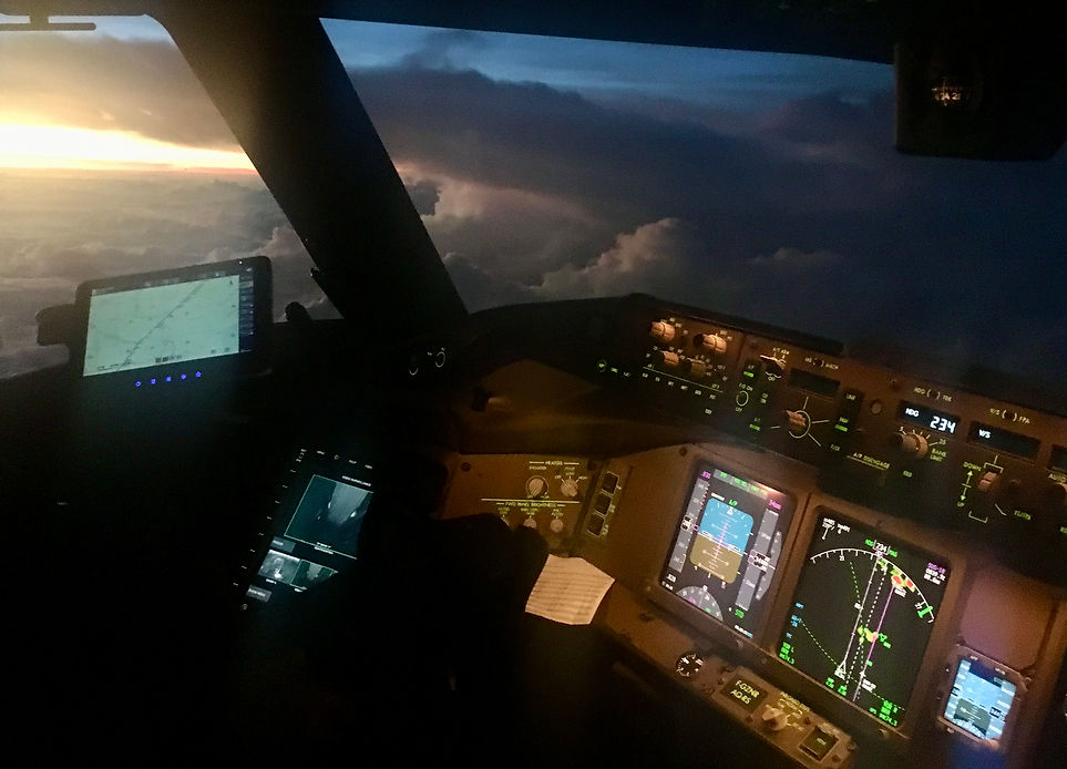 Tableau de bord d'un 777 à la tombée de la nuit face à des nuages d'orage