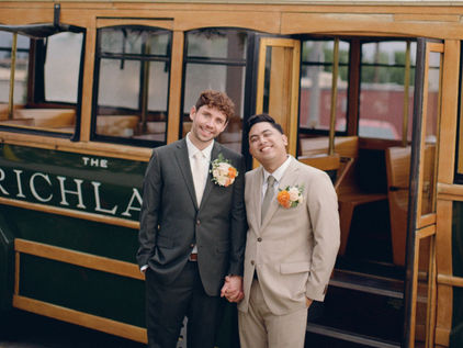 The grooms smiling, in the background is the Richland bus