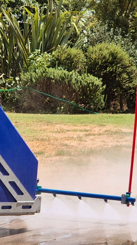 High-pressure street washer attachment cleaning a driveway in rural Waikato