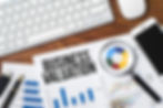 Business valuation report with computer and magnifier
