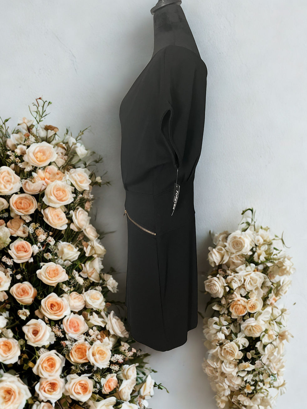 Thumbnail: Black dress with gold accents, displayed on a mannequin, with floral background.