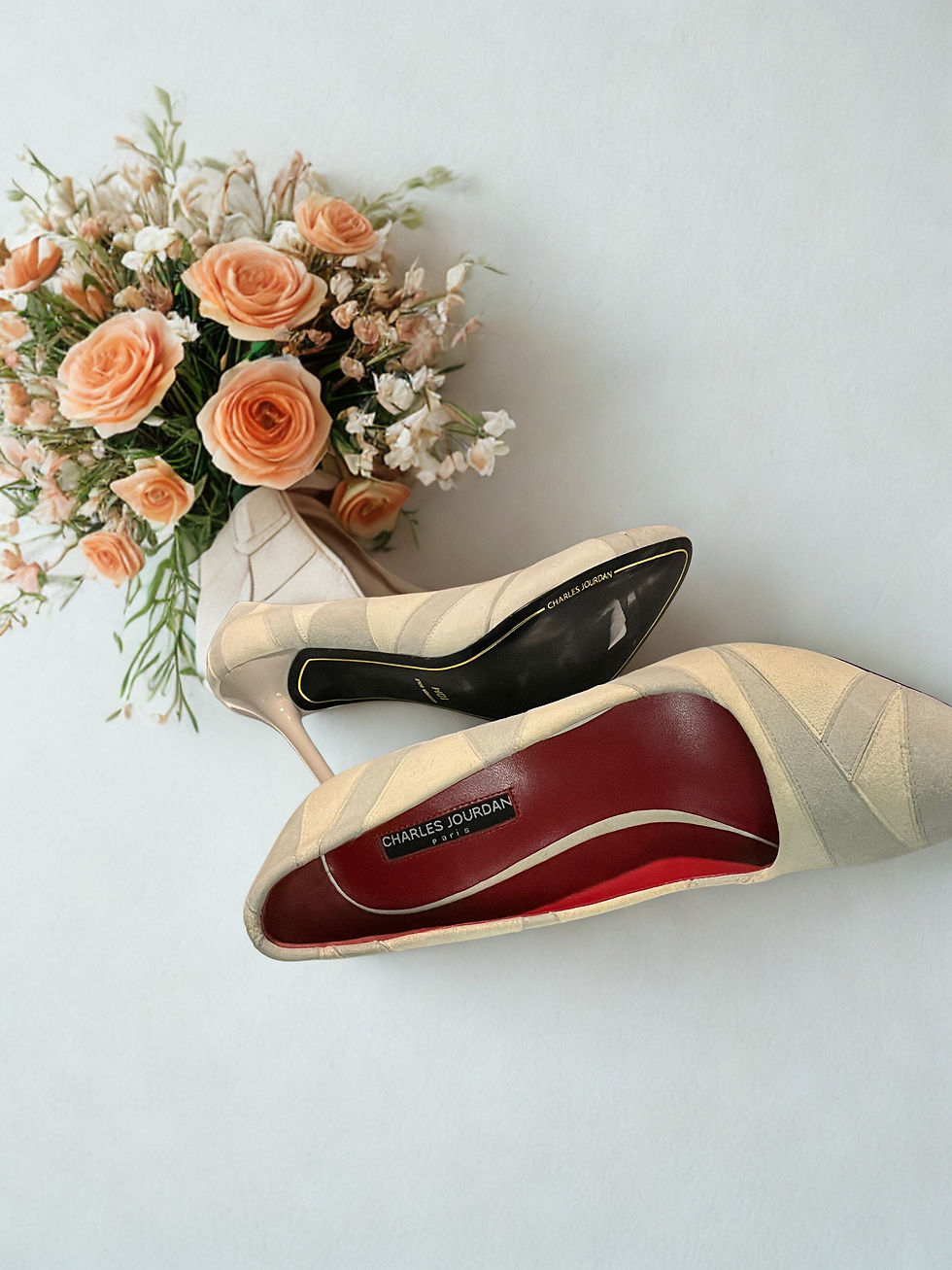Thumbnail: Elegant beige Charles Jourdan Paris Pump 10M with lovely floral arrangement background.