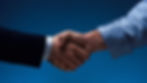 Close-up of a professional handshake on a dark blue background