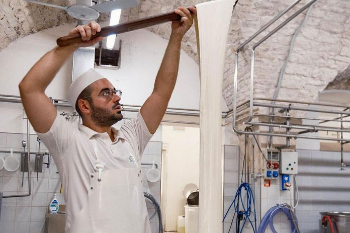 Cheese maker preparing fresh mozzarella during a traditional mozzarella experience in Ostuni.