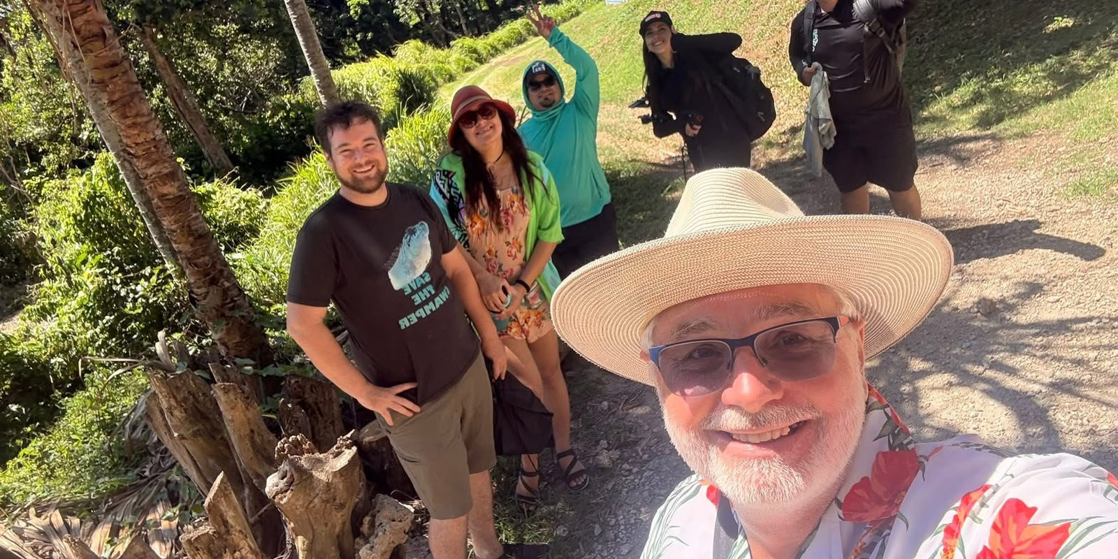 The Hidden Wonders crew smiling on a jungle trail in the Bay Islands