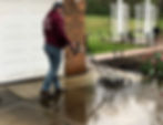 Young professional operates a professional cement power washer as he cleans off mildew and stains, leaving the driveway looking brand new.