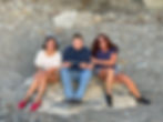 Three Penn Residential residents smiling for a photo under a rock formation during a walk on the trails at Ohiopyle Park.