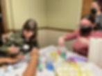 Residents gathered around a table coloring eggs as an Easter activity.